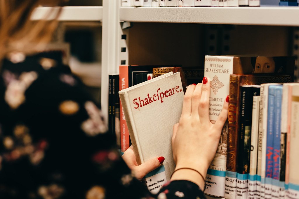 Student choosing books in a university library - TOEFL coaching in Hyderabad